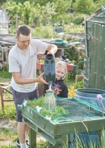 Tom and Louisa watering their allotment